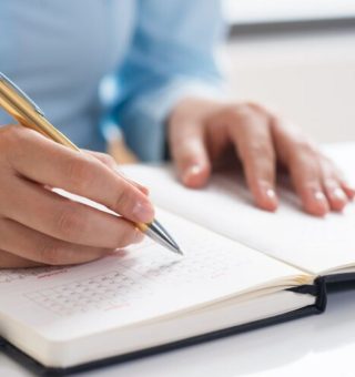 Uma pessoa faz anotações com a caneta em sua agenda sobre o Cronograma ProUni 2025