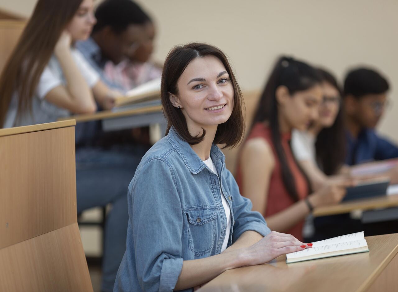 Universitária posa sorrindo durante a aula