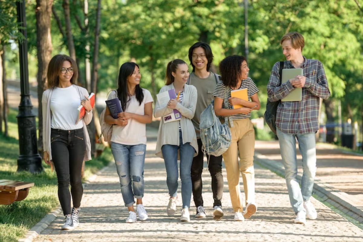 Um grupo de alunos andando pelo campus após a aprovação no Bolsa Permanência ProUni 2025.