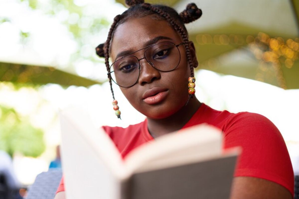 Uma aluna lendo um livro. Ela estuda Física no ENEM 2025
