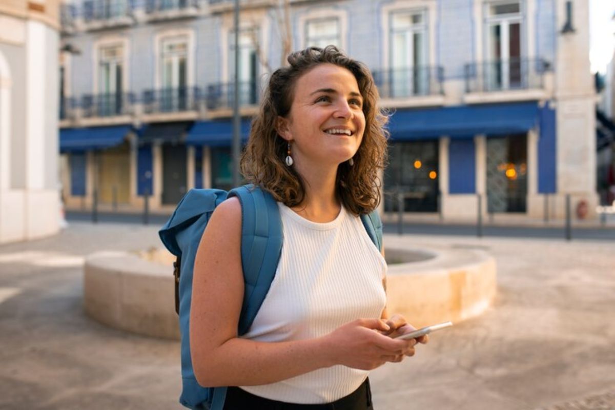 Uma aluna com mochila nas costas. Ela está feliz após ver Como Receber Bolsa Permanência do ProUni em 2025