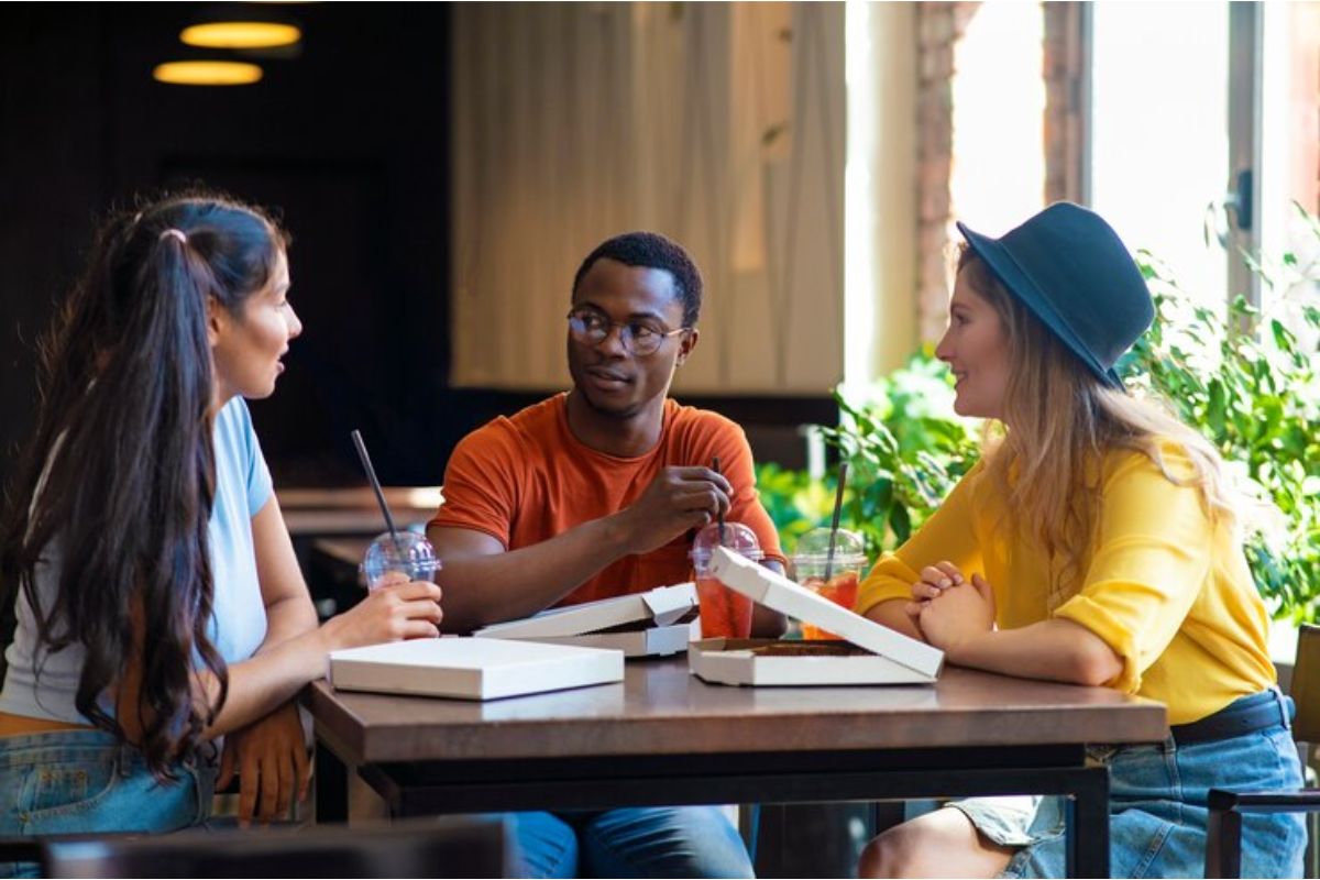 Três alunos sentados em torno de uma mesa estudam Línguas Estrangeiras no ENEM 2025