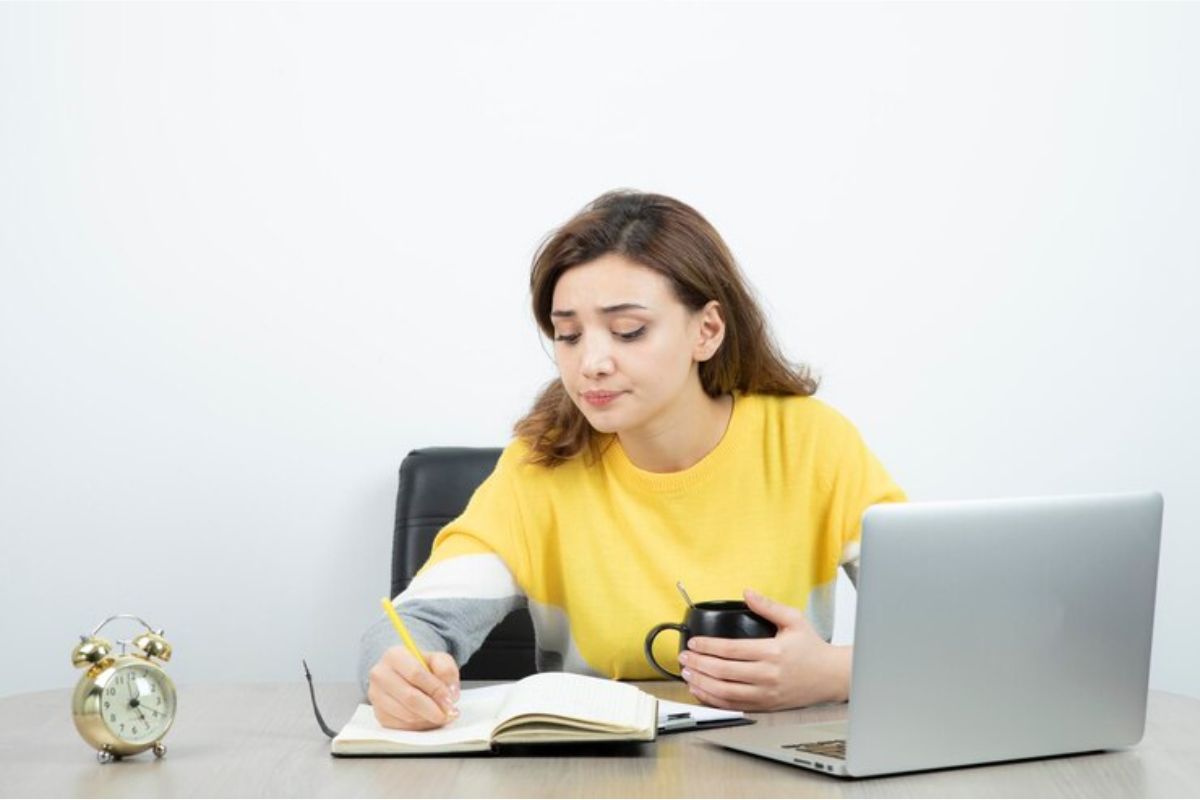 Uma menina de camiseta amarela usa seu notebook para estudar para a Prova ETEC 2025