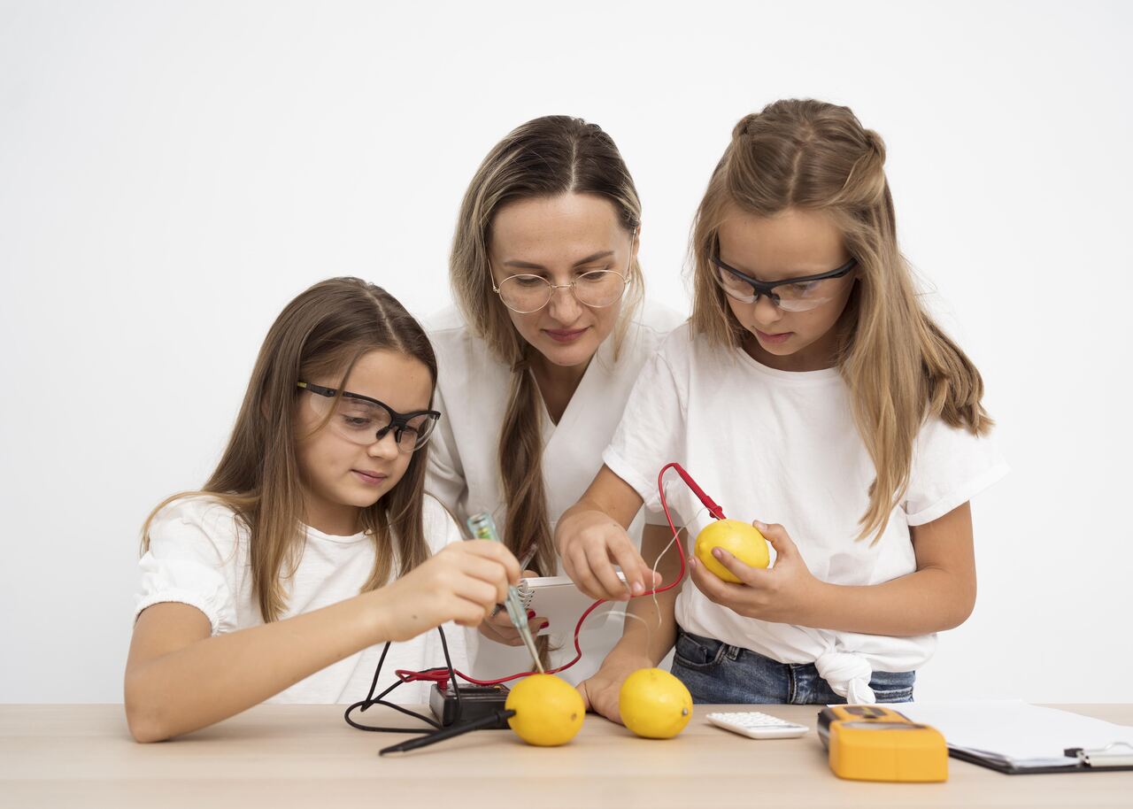 Crianças trabalham em projeto maker sob supervisão de professora