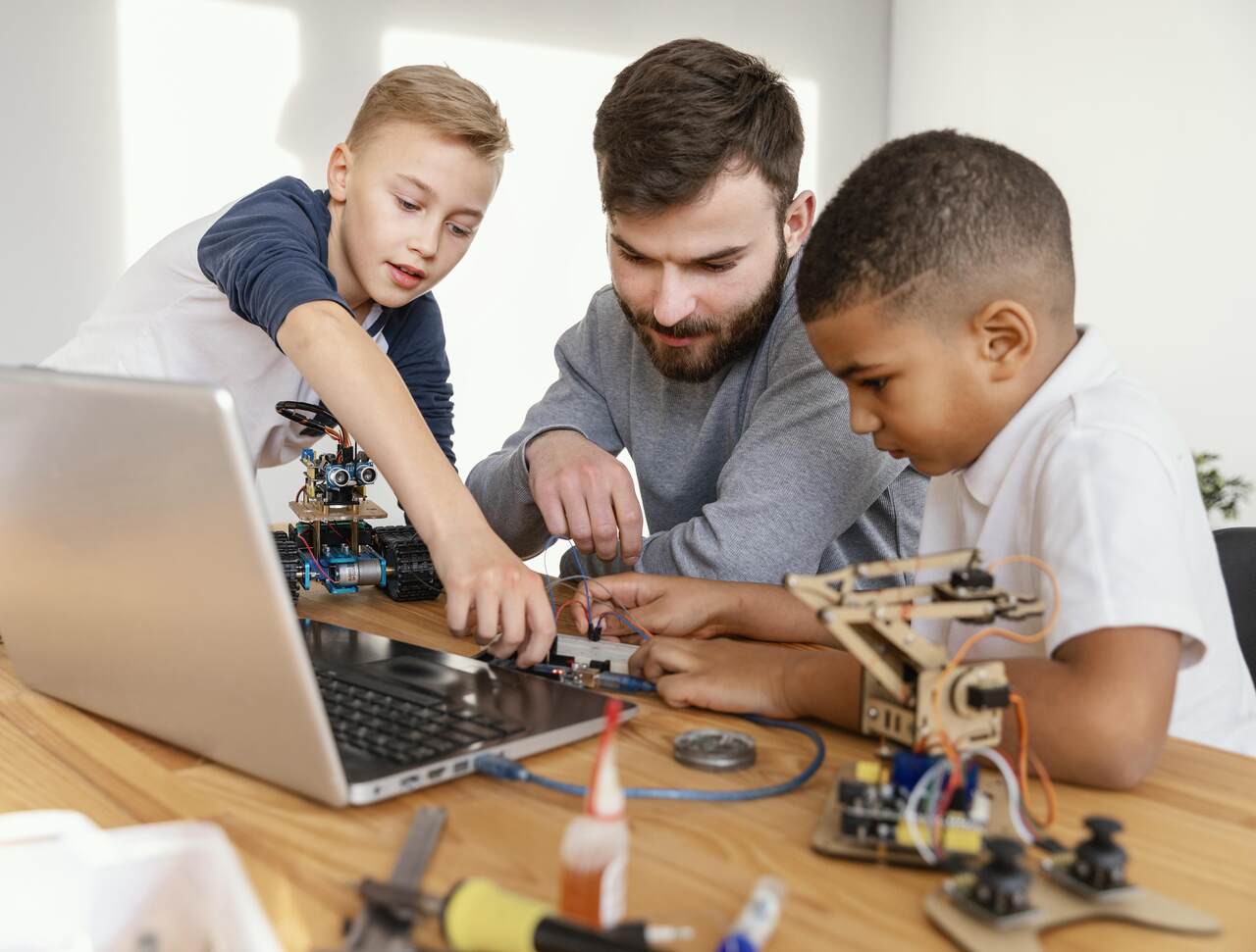 Crianças trabalham em projeto maker sob supervisão de professor