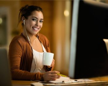 Uma menina sentada em frente ao seu computador, se inscreve no curso ETEC Administração 2025