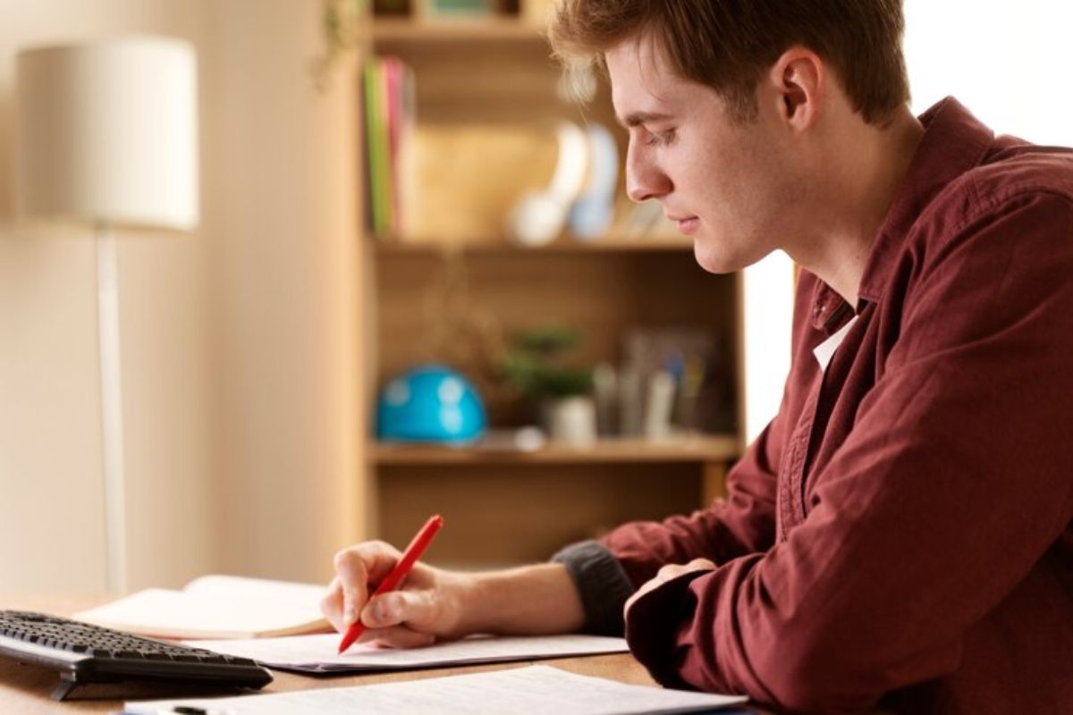 Um jovem em frente ao seu notebook consulta o que ele pode aprender no Curso de Logística ETEC 2025