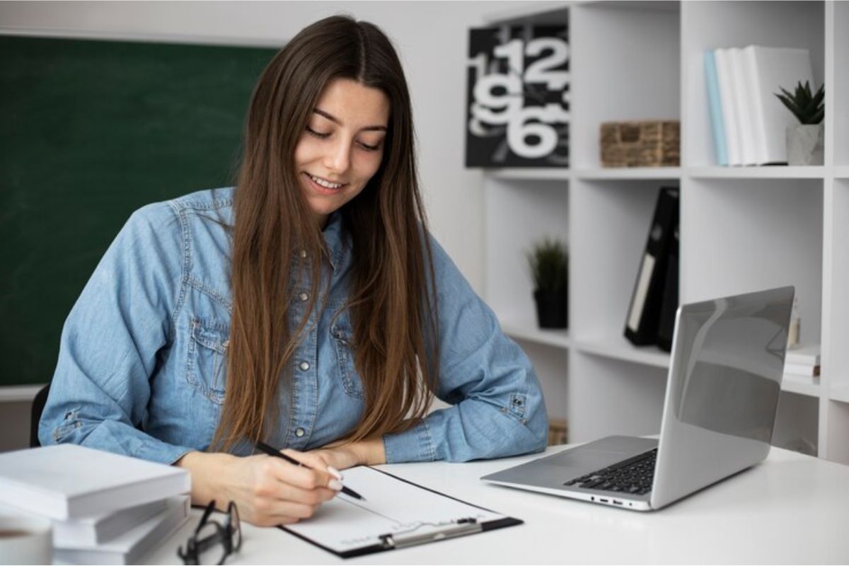 Uma estudante se preparando em casa. Ela procura no notebook em sua mesa os cursos menos concorridos da ETEC 2025