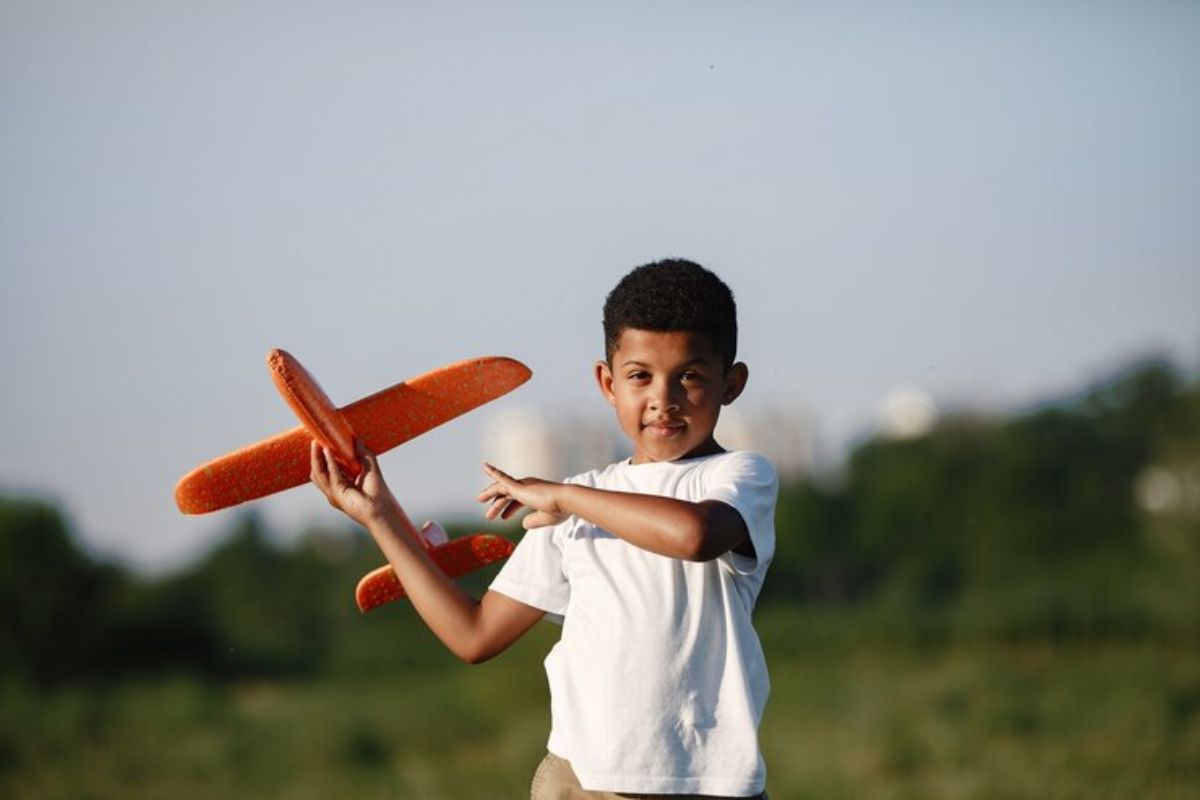 Um pequeno estudante de uma das escolas cívico-militares em SP com um avião de brinquedo na mão