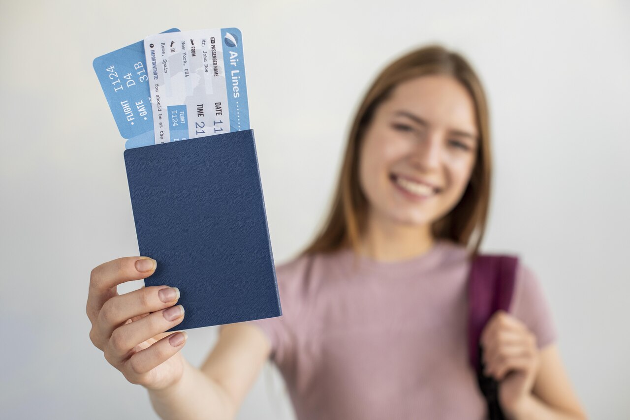 Jovem mostra passaporte com passagens aéreas dentro 