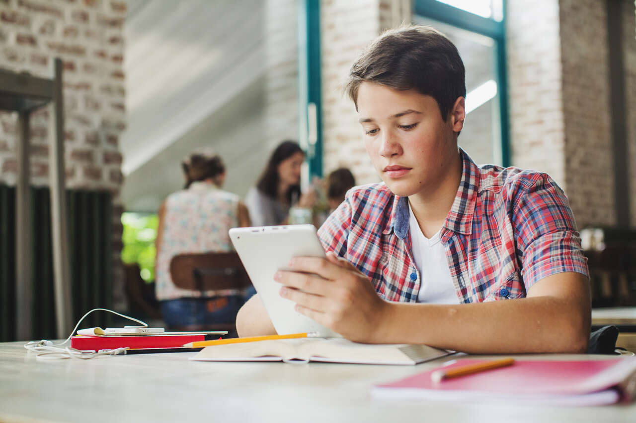 Jovem estuda em seu tablet