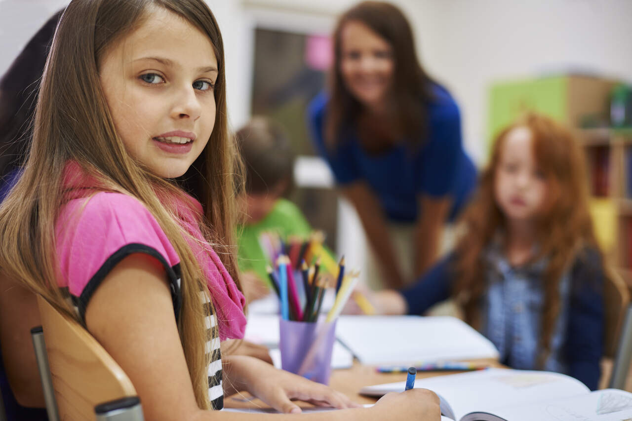 Menina posa para foto durante a aula 